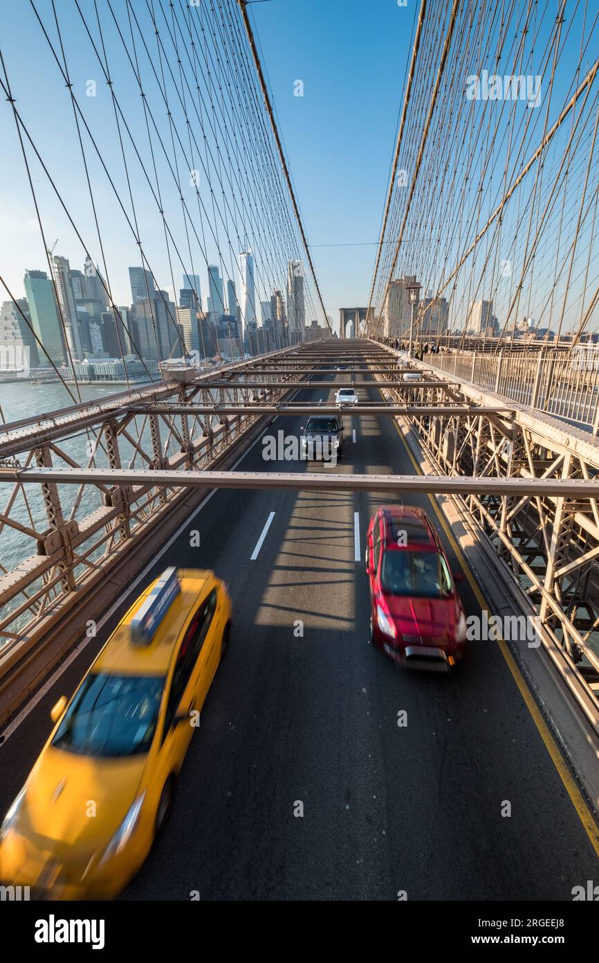 Un taxi jaune et une voiture rouge en vitesse à travers le pont de Brooklyn vu d'en haut Banque D'Images