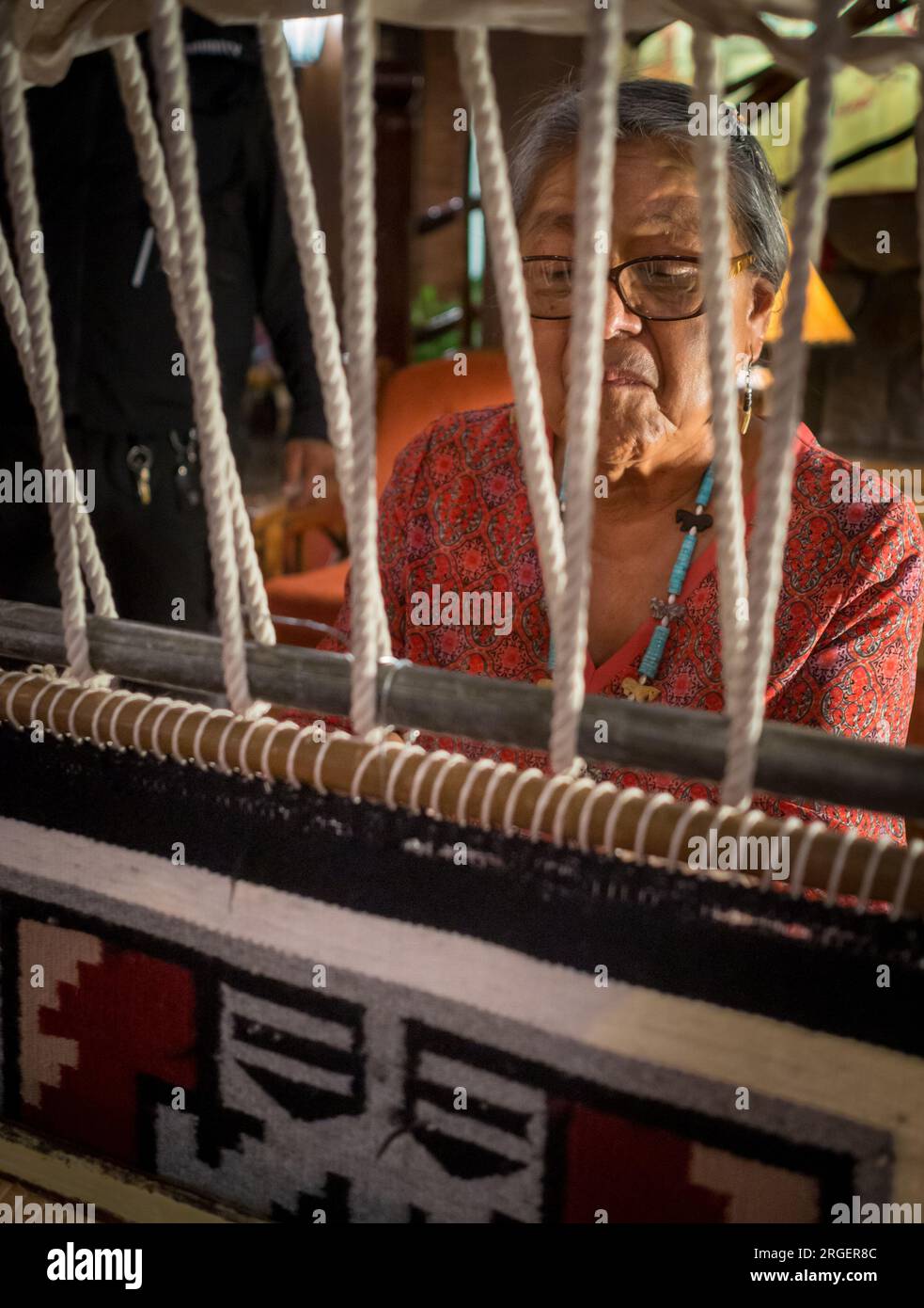 Une femme amérindienne fabrique un tapis dans le hall de l'hôtel El Rancho à Gallup, au Nouveau-Mexique. Photo de Liz Roll Banque D'Images