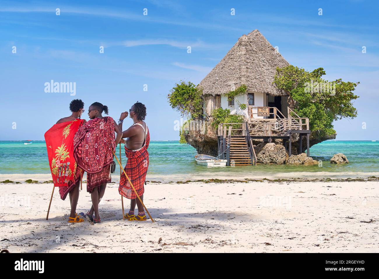 Masai hommes sur la plage, le Rock Restaurant en arrière-plan, Pingwe, Zanzibar, Tanzanie, Afrique de l'est Banque D'Images