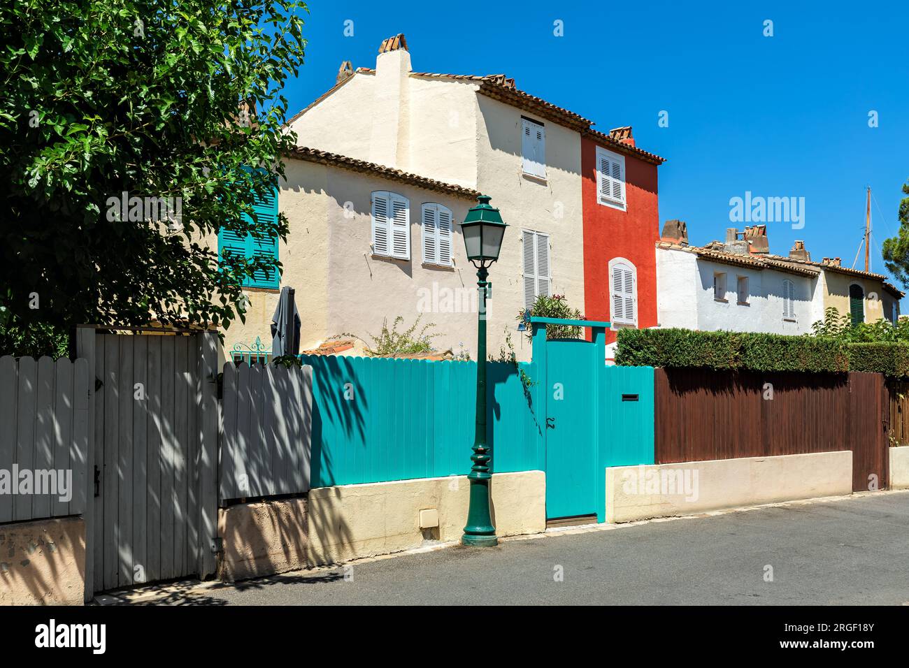 Maisons colorées derrière la clôture en bois sous le ciel bleu à Port Grimaud - ville sur la Côte d'Azur. Banque D'Images