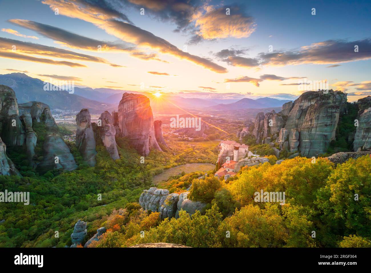 Météores, Grèce. Paysage panoramique des Météores, Grèce au coucher du soleil romantique avec soleil réel et ciel de coucher du soleil. Meteora - incroyable roche de grès pour Banque D'Images