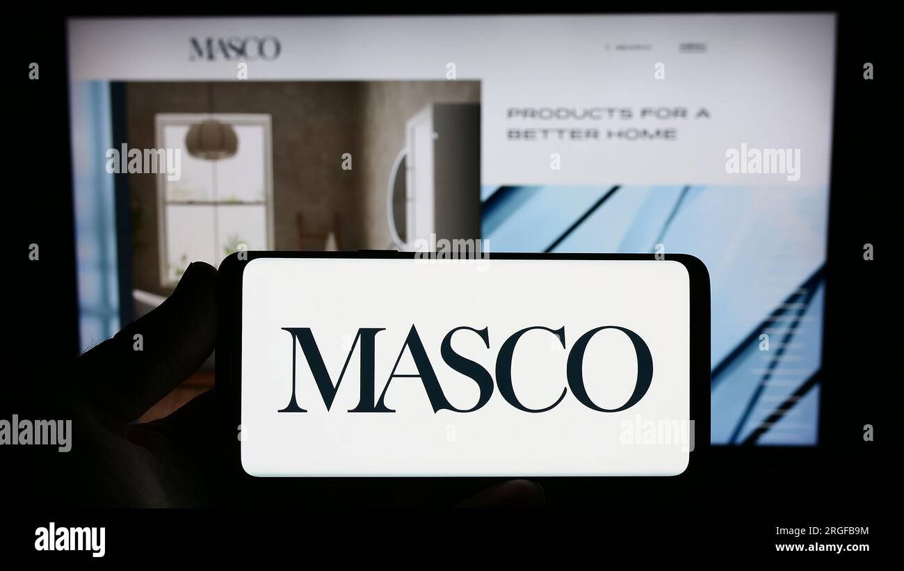 Personne tenant le smartphone avec le logo de la société américaine de rénovation domiciliaire Masco Corporation sur l'écran en face du site Web. Concentrez-vous sur l'affichage du téléphone. Banque D'Images