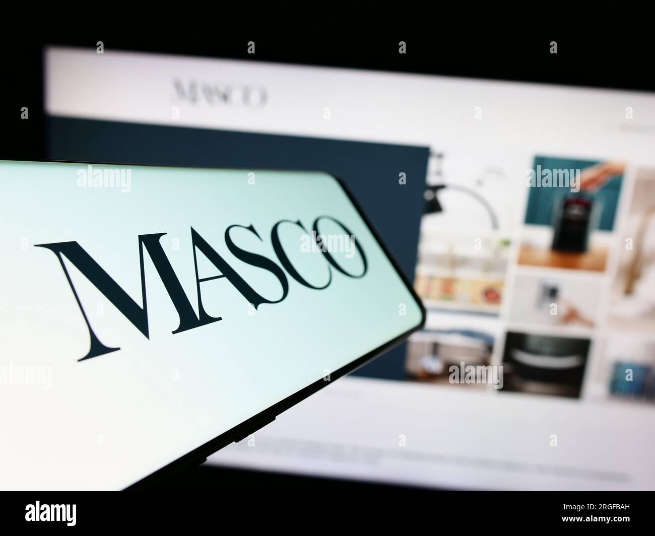 Téléphone portable avec logo de la société américaine d'amélioration de la maison Masco Corporation sur l'écran en face du site Web. Effectuez le focus sur la gauche de l'écran du téléphone. Banque D'Images