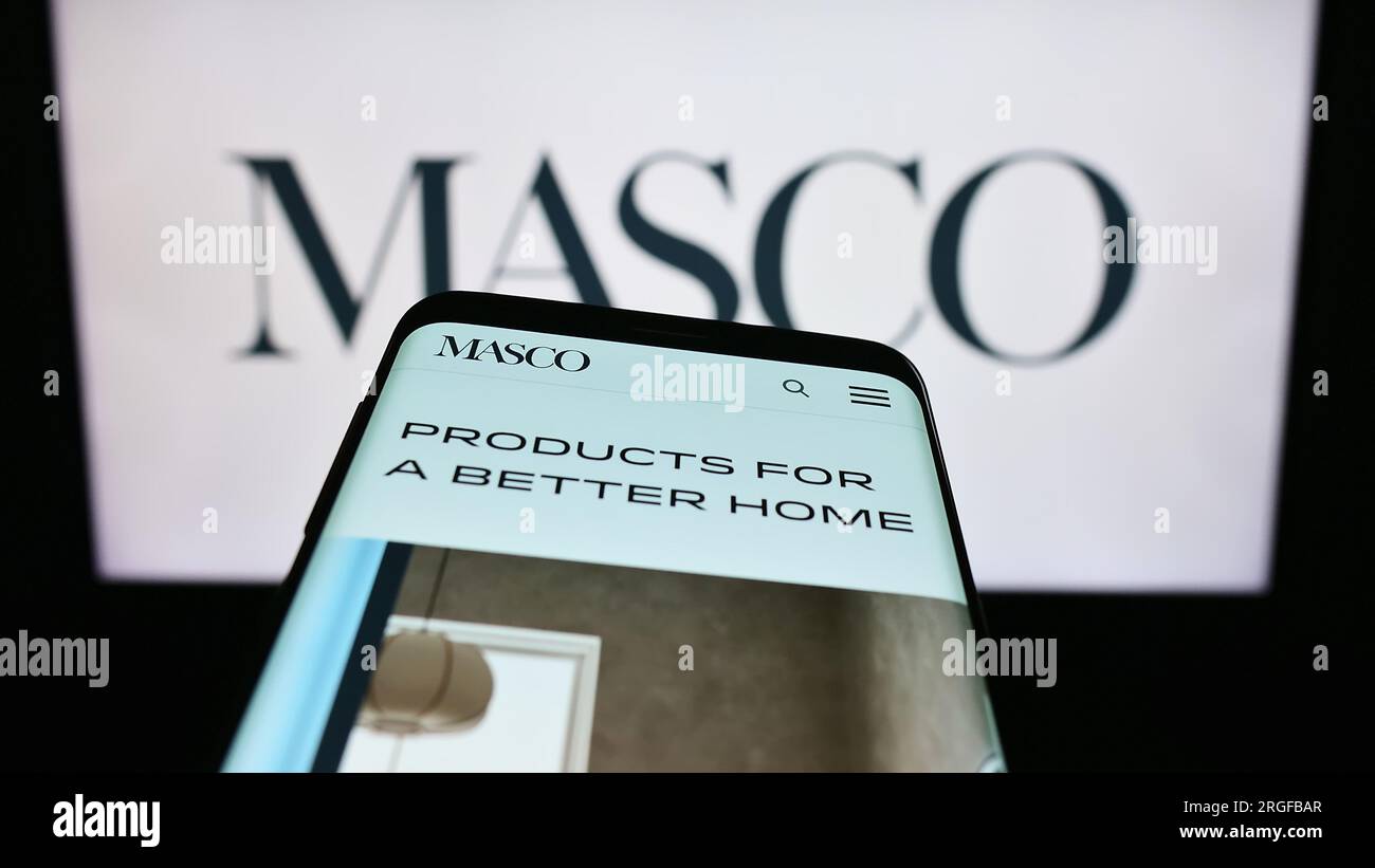 Téléphone mobile avec la page Web de la société américaine de rénovation domiciliaire Masco Corporation sur l'écran en face du logo. Effectuez le focus sur le coin supérieur gauche de l'écran du téléphone. Banque D'Images