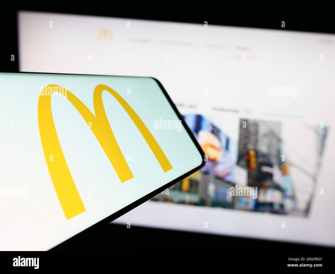Téléphone portable avec logo de la société américaine de restauration rapide McDonald's Corporation sur l'écran devant le site Web. Concentrez-vous sur le centre de l'écran du téléphone. Banque D'Images