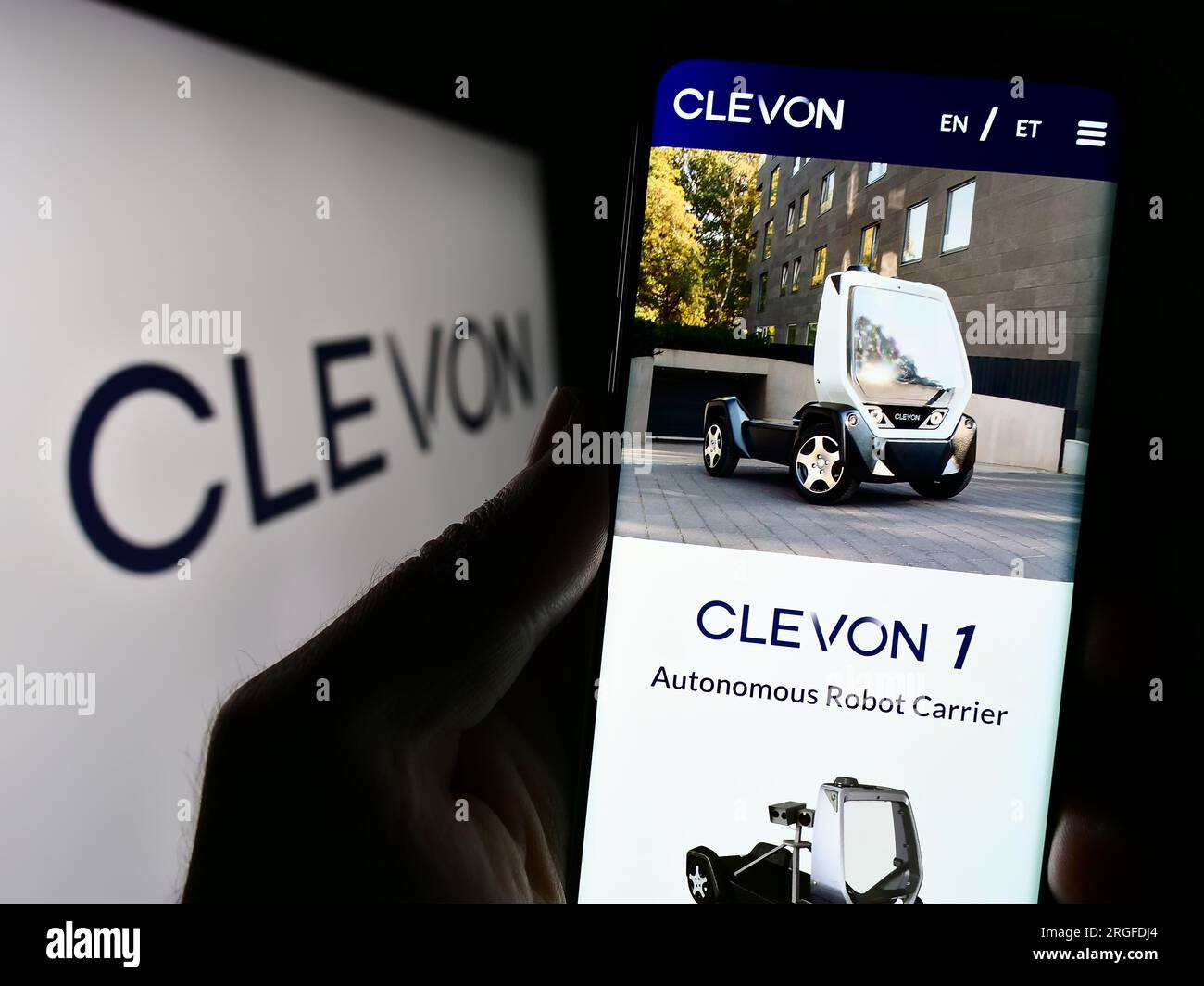 Personne tenant le téléphone portable avec la page Web de la société de véhicule autonome Estionian Clevon COMME sur l'écran avec logo. Concentrez-vous sur le centre de l'écran du téléphone. Banque D'Images