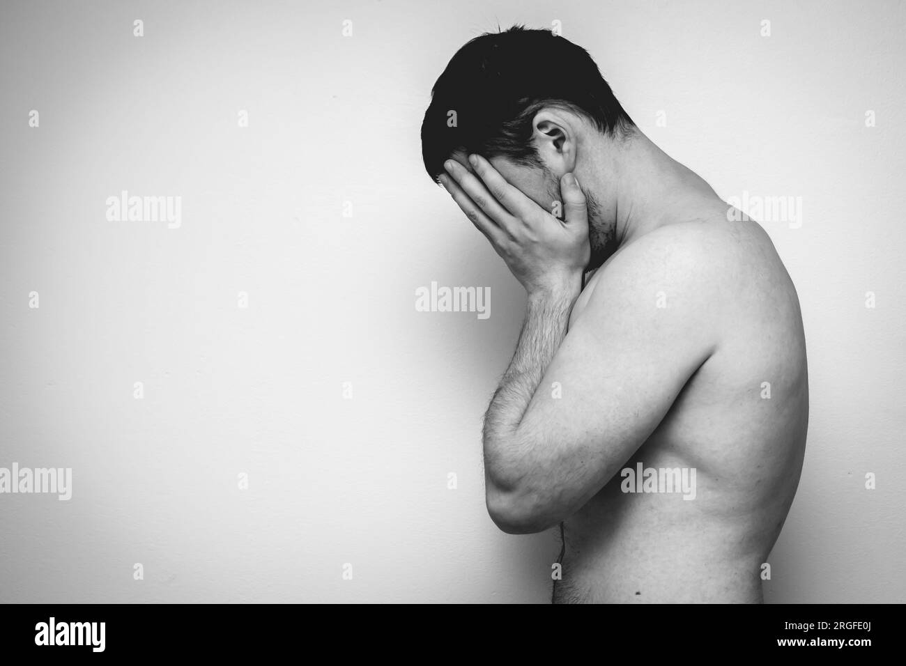 Un homme couvrant son visage avec son bras. photo en noir et blanc. Banque D'Images