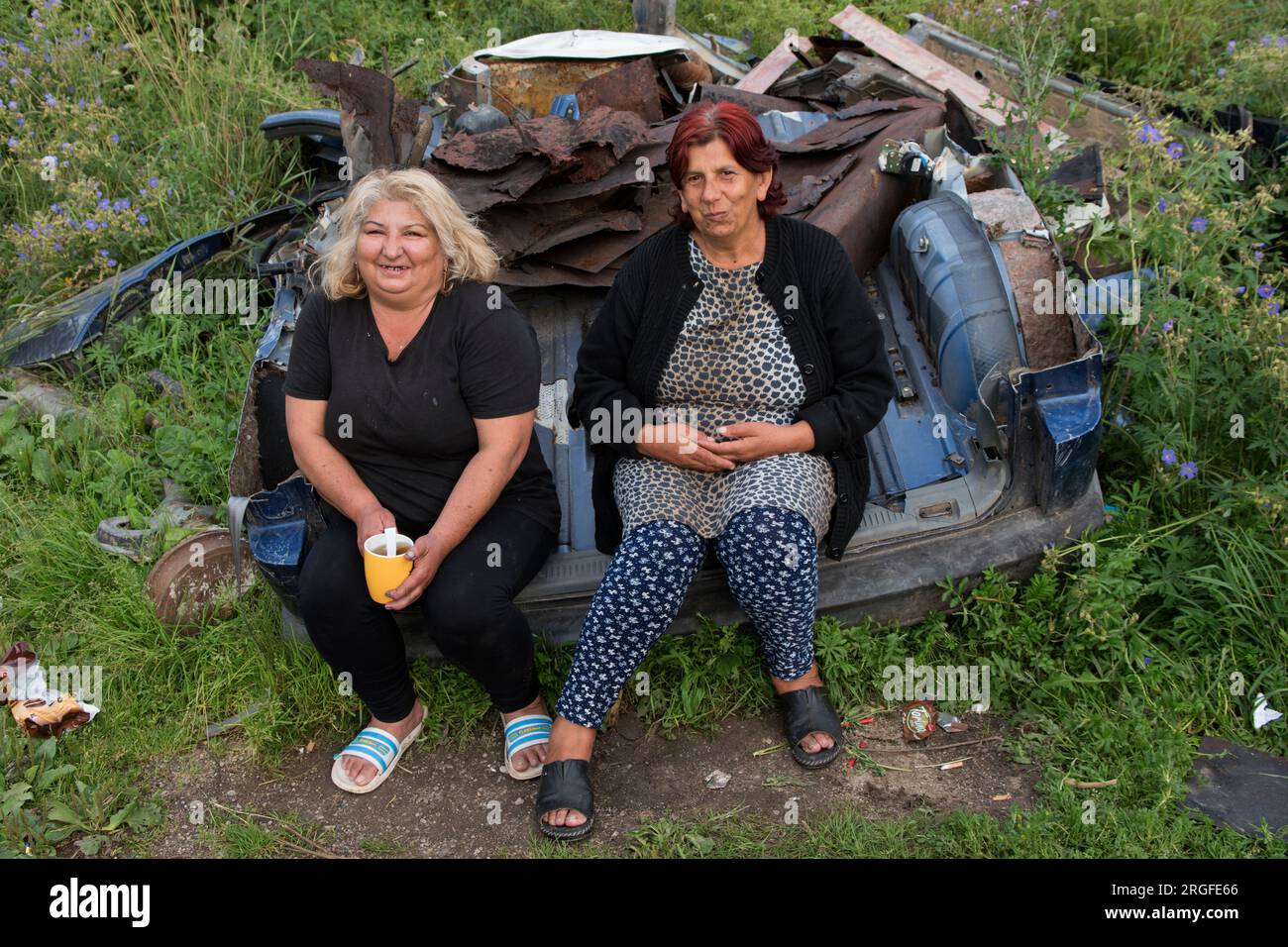 Grands-mères gitans roms elles sont assises sur une voiture mise au rebut en face de leur maison. Colonie tzigane à la périphérie de Sumiac, district de Brezno, Slovaquie août 2023. HOMER SYKES des années 2020 Banque D'Images