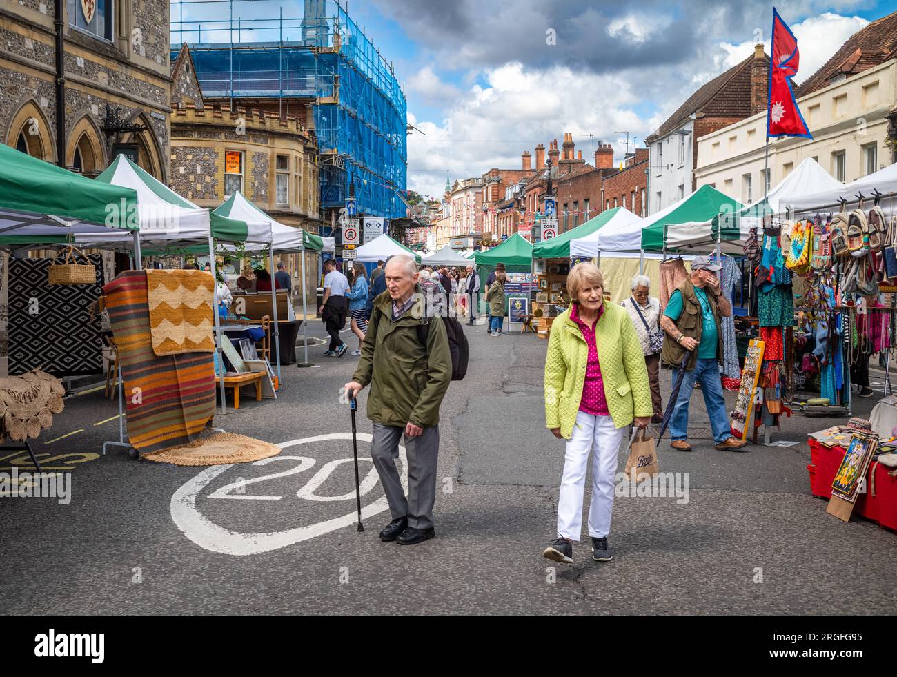 Un couple de personnes âgées se promènent dans le marché d'antiquités et d'artisanat du week-end de High Street, Winchester, Hampshire, Royaume-Uni. Le marché a lieu le samedi et Banque D'Images