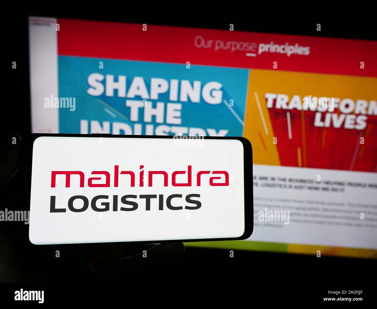 Personne tenant le smartphone avec le logo de la société indienne Mahindra Logistics Ltd. Sur l'écran en face du site Web. Concentrez-vous sur l'affichage du téléphone. Banque D'Images
