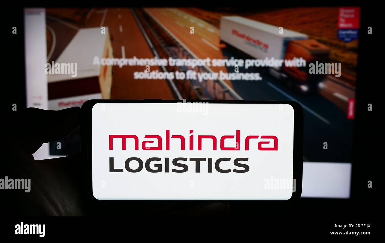 Personne tenant le téléphone portable avec le logo de la société indienne Mahindra Logistics Ltd. Sur l'écran devant la page Web de l'entreprise. Concentrez-vous sur l'affichage du téléphone. Banque D'Images