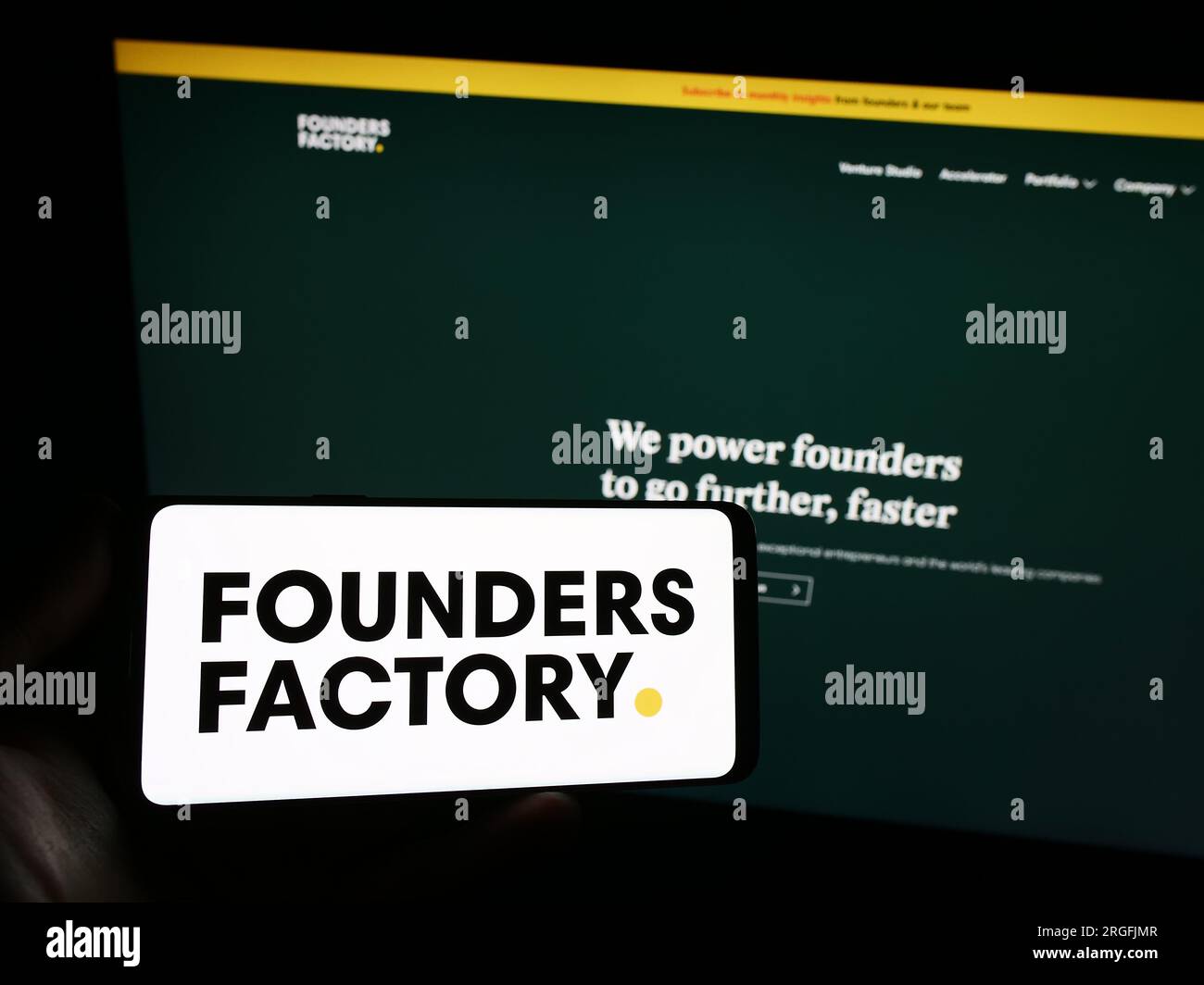 Personne tenant le smartphone avec le logo de la société britannique Founders Factory Ltd. Sur l'écran devant le site Web. Concentrez-vous sur l'affichage du téléphone. Banque D'Images