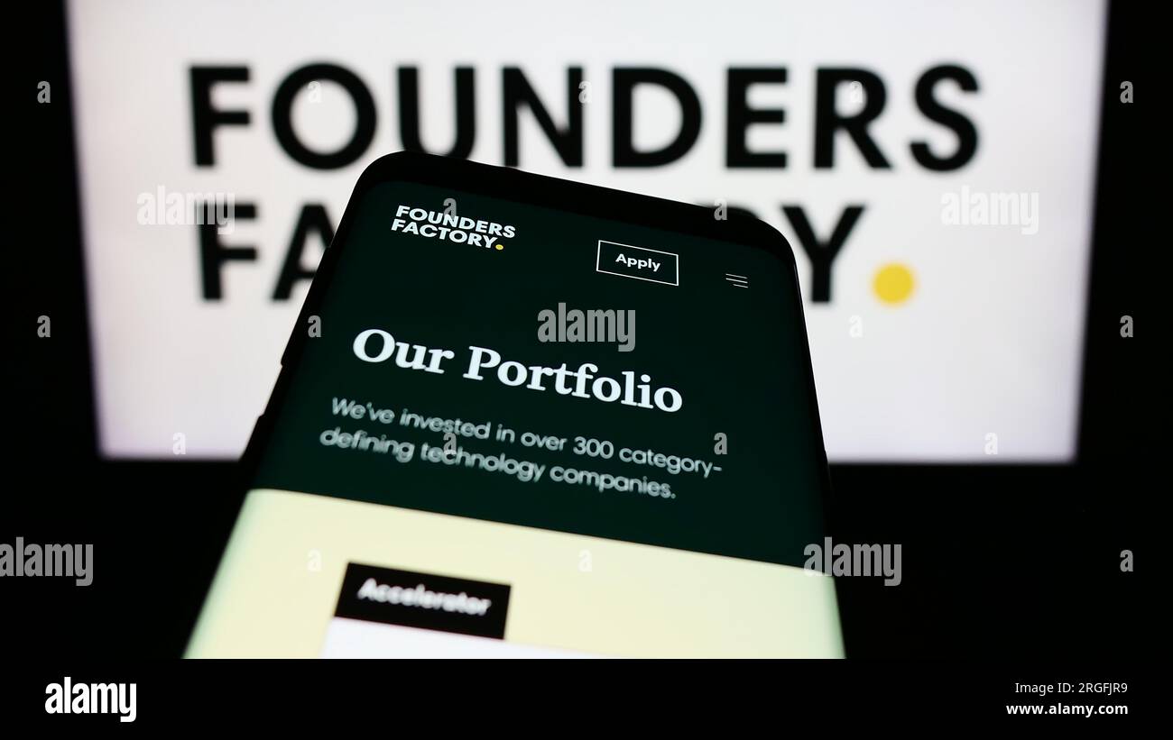 Téléphone portable avec le site Web de la société britannique Founders Factory Ltd. Sur l'écran devant le logo de l'entreprise. Effectuez le focus sur le coin supérieur gauche de l'écran du téléphone. Banque D'Images
