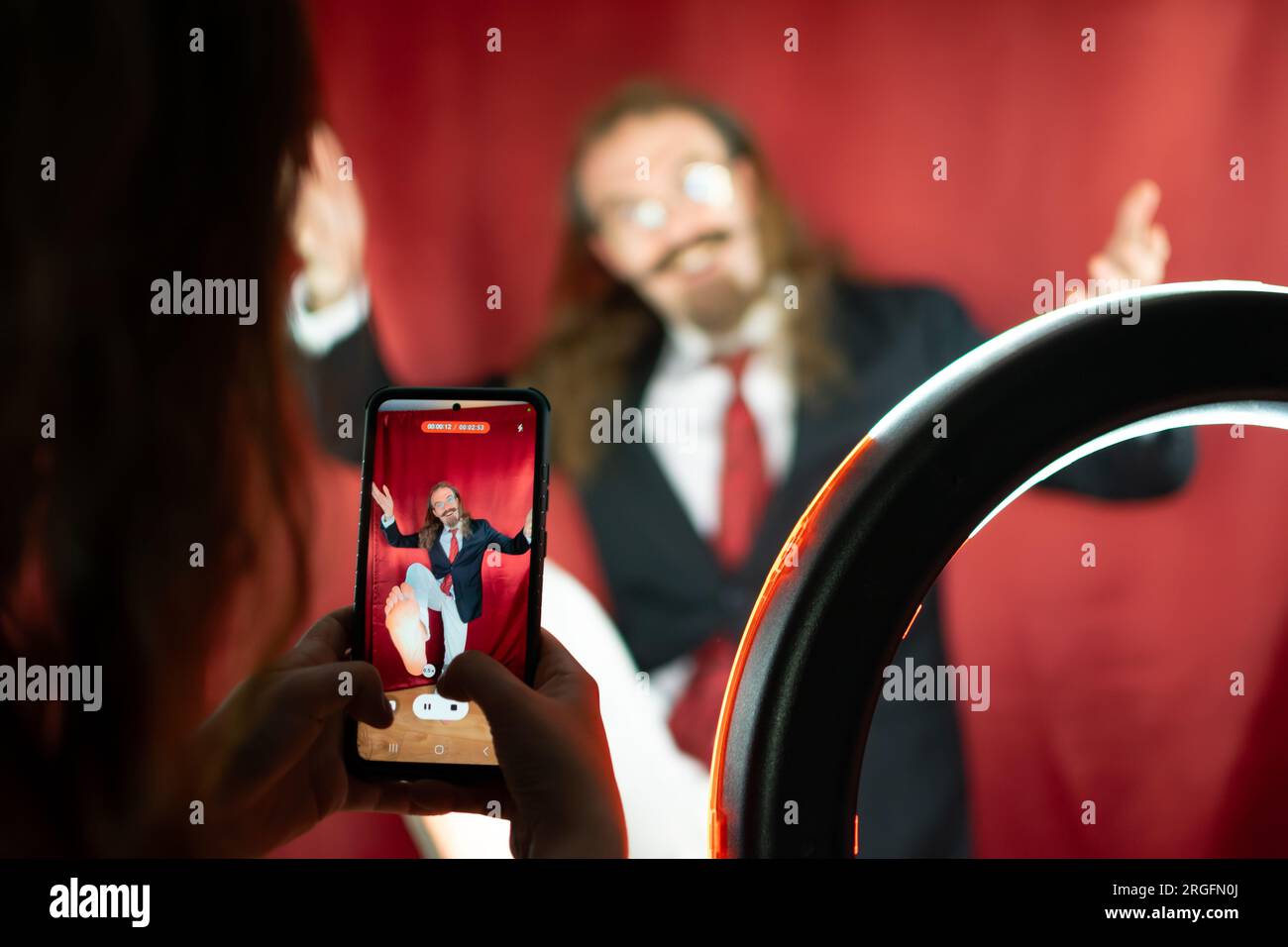Téléphone portable Shooting Funny Caucasian Man au studio de photographie pour les médias sociaux Banque D'Images