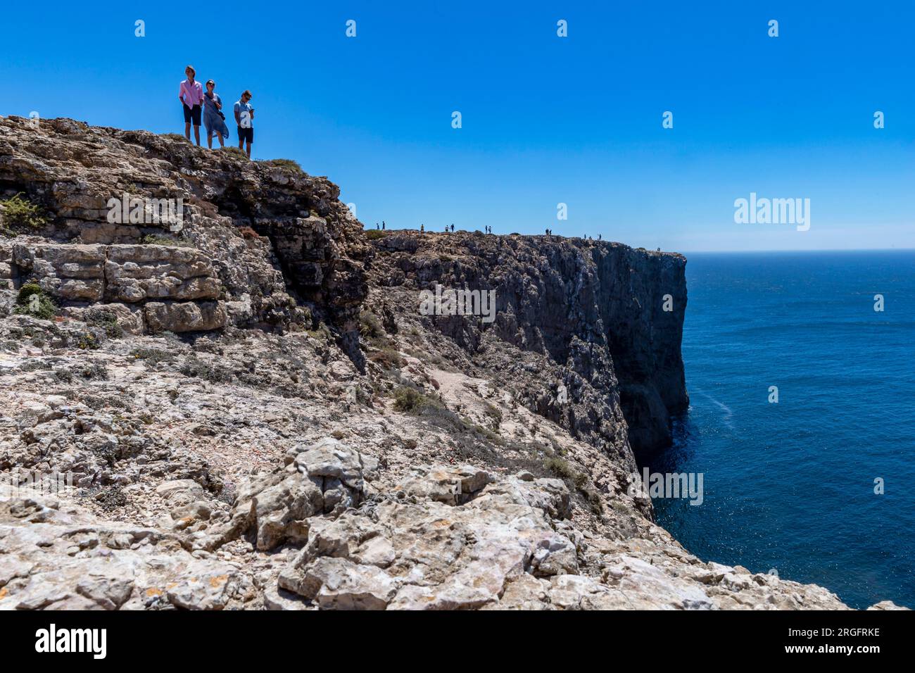 trois personnes sur les rochers au-dessus de la mer Banque D'Images