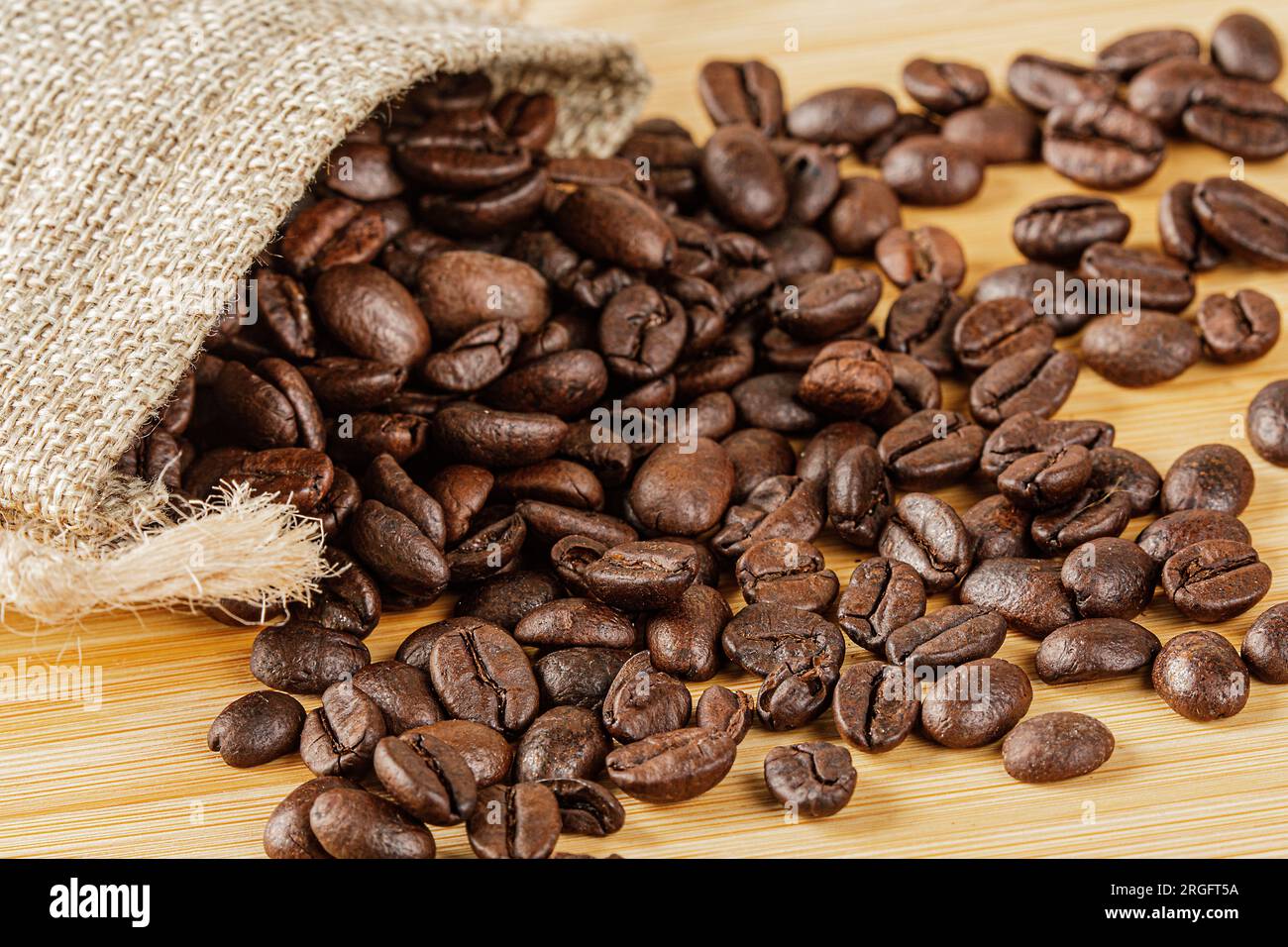 Gros plan de délicieux grains de café rôtis sur un fond en bois avec espace de copie Banque D'Images