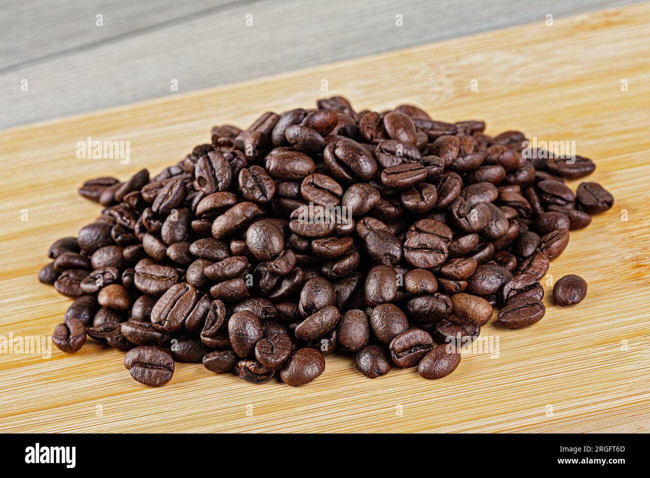 Gros plan de délicieux grains de café rôtis sur un fond en bois avec espace de copie Banque D'Images