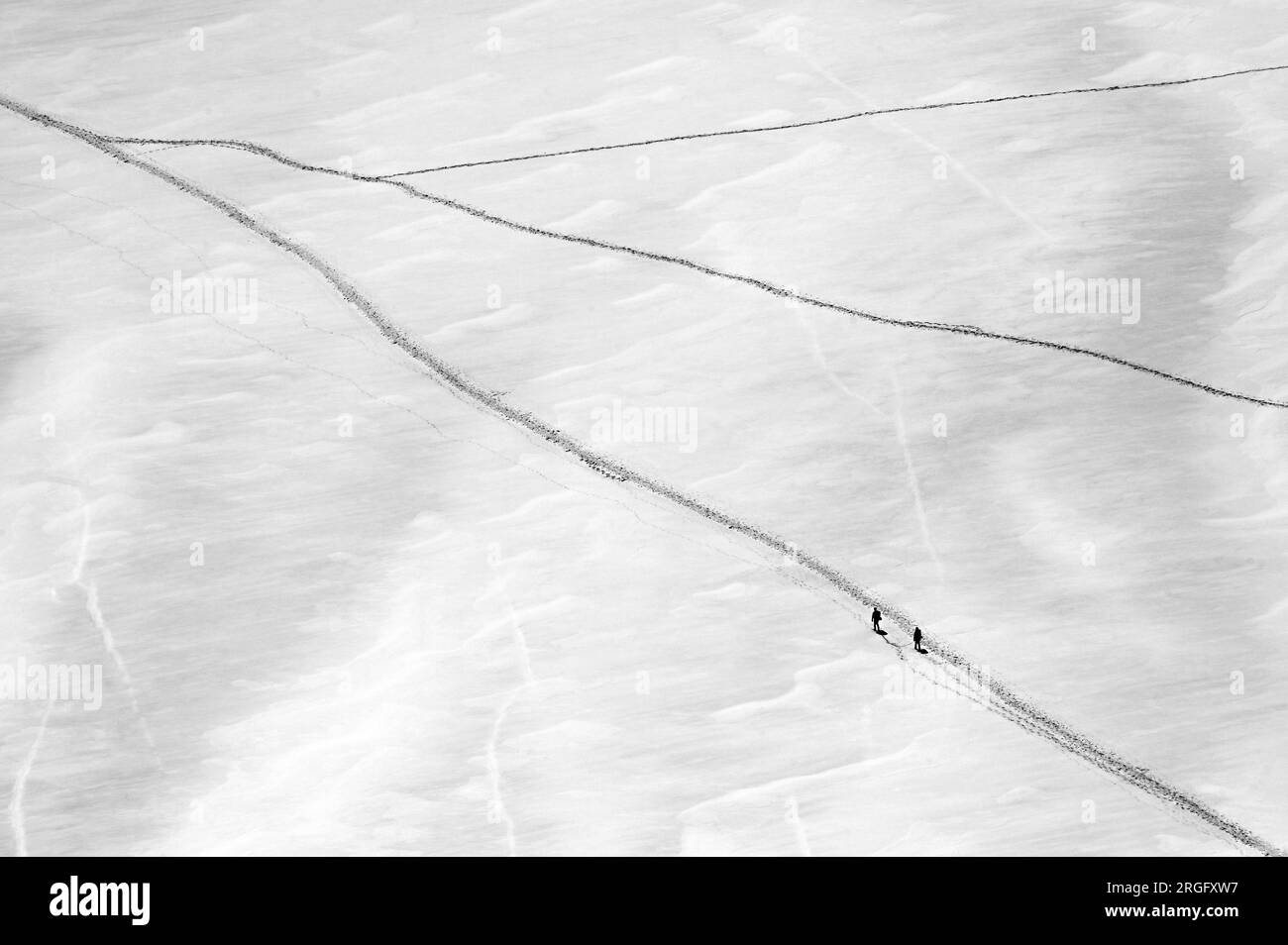 Deux grimpeurs marchant sur le glacier géant près de l'aiguille du midi dans le massif du Mont blanc en noir et blanc Banque D'Images