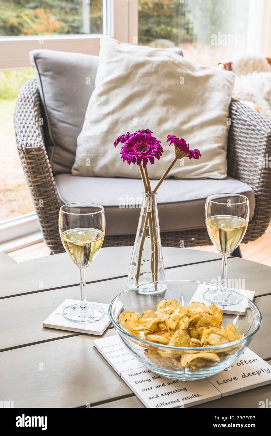 Table basse avec verres à vin et une collation dans un jardin d'hiver, verticale Banque D'Images