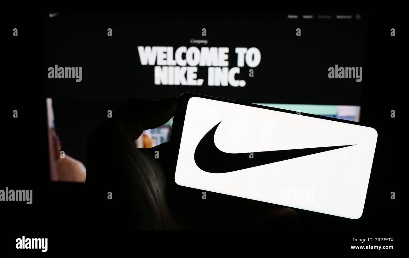 Personne tenant un smartphone avec le logo de la société américaine de vêtements de sport Nike Inc. Sur l'écran devant le site Web. Concentrez-vous sur l'affichage du téléphone. Banque D'Images
