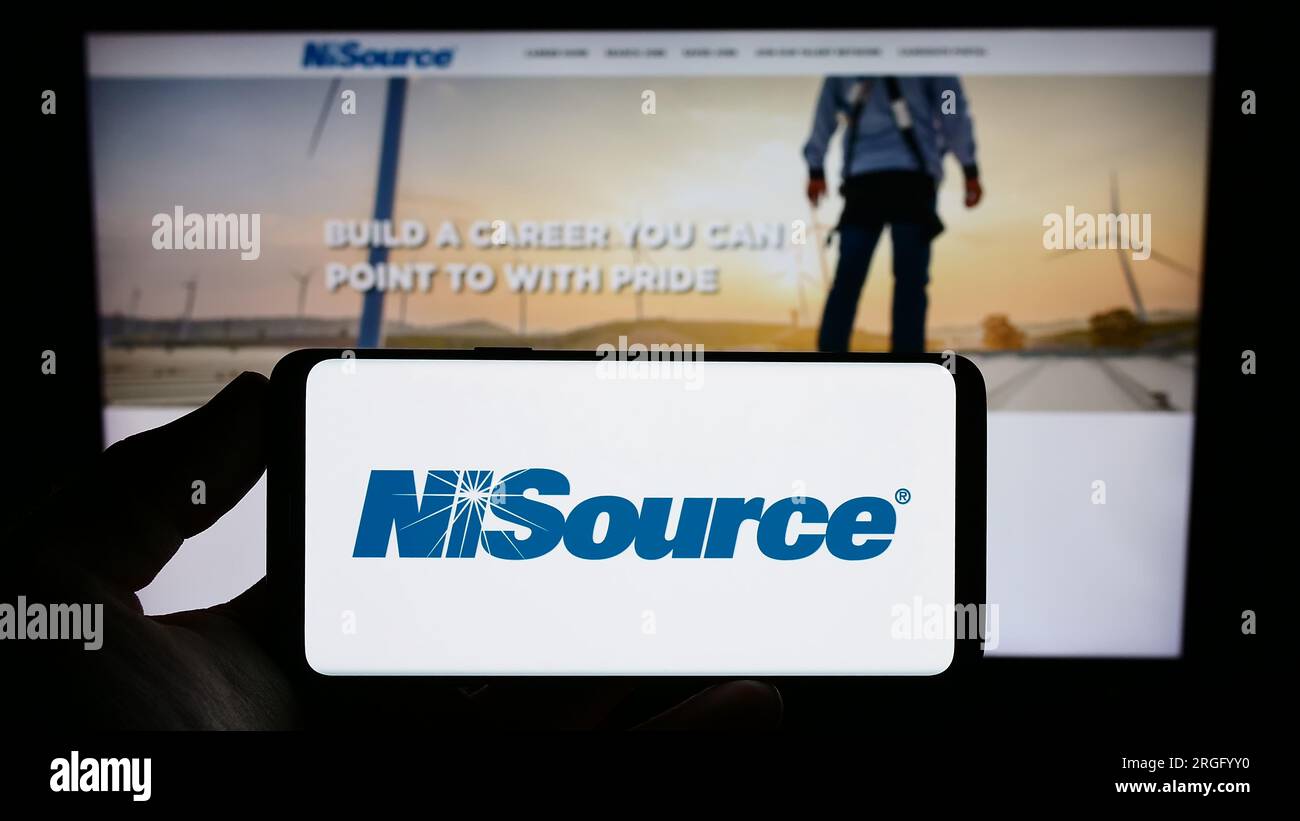 Personne tenant un smartphone avec le logo de la société de services publics américaine NiSource Inc. Sur l'écran devant le site Web. Concentrez-vous sur l'affichage du téléphone. Banque D'Images