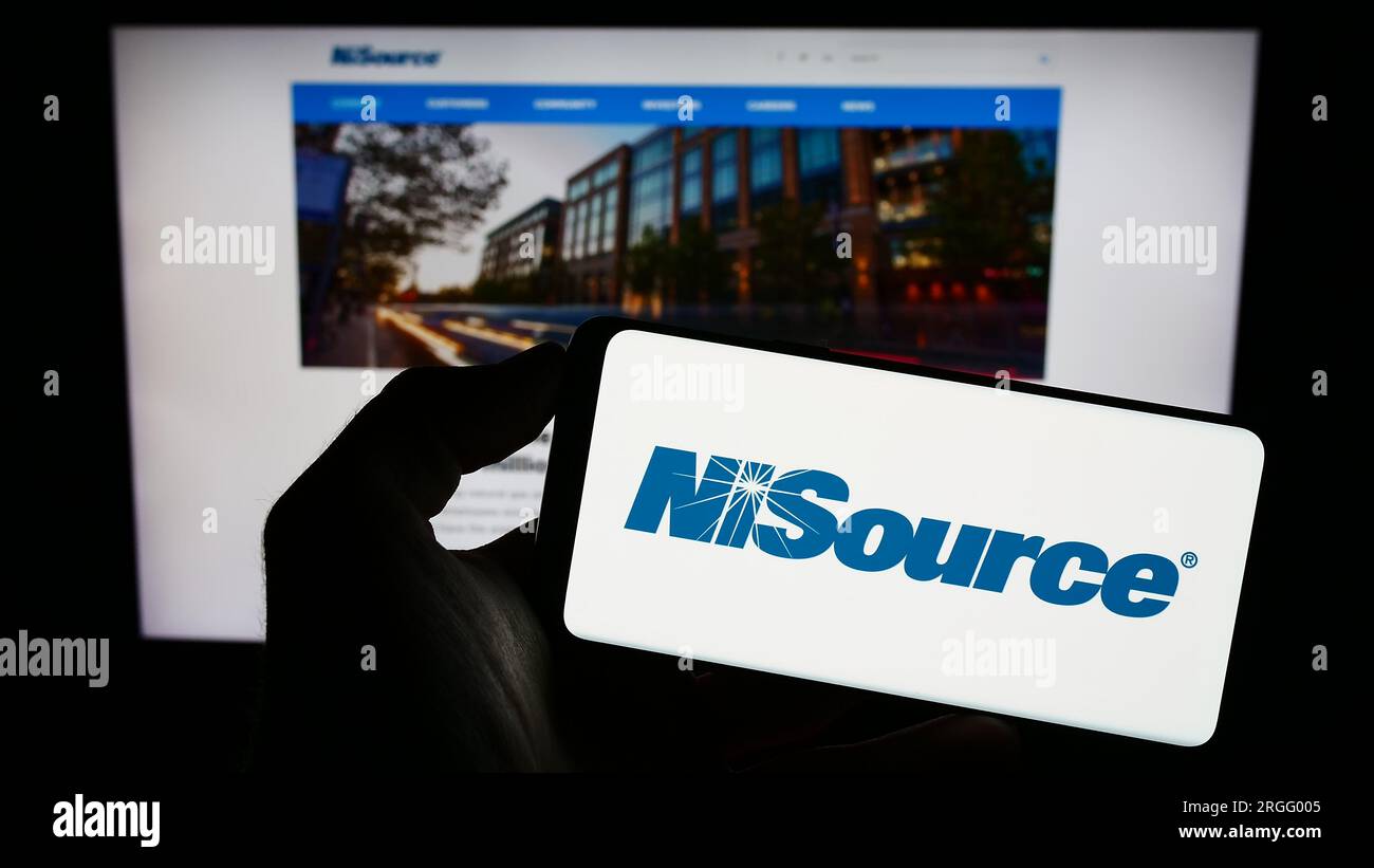 Personne tenant un téléphone portable avec le logo de la société de services publics américaine NiSource Inc. Sur l'écran devant la page Web de l'entreprise. Concentrez-vous sur l'affichage du téléphone. Banque D'Images