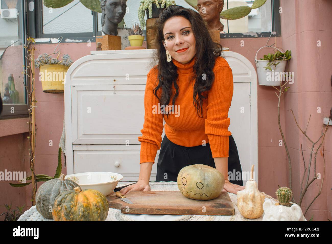 Portrait de femme caucasienne adulte artiste décorant la citrouille pour Halloween, faisant du contenu pour ses réseaux sociaux, elle est debout avec ses mains sur t Banque D'Images