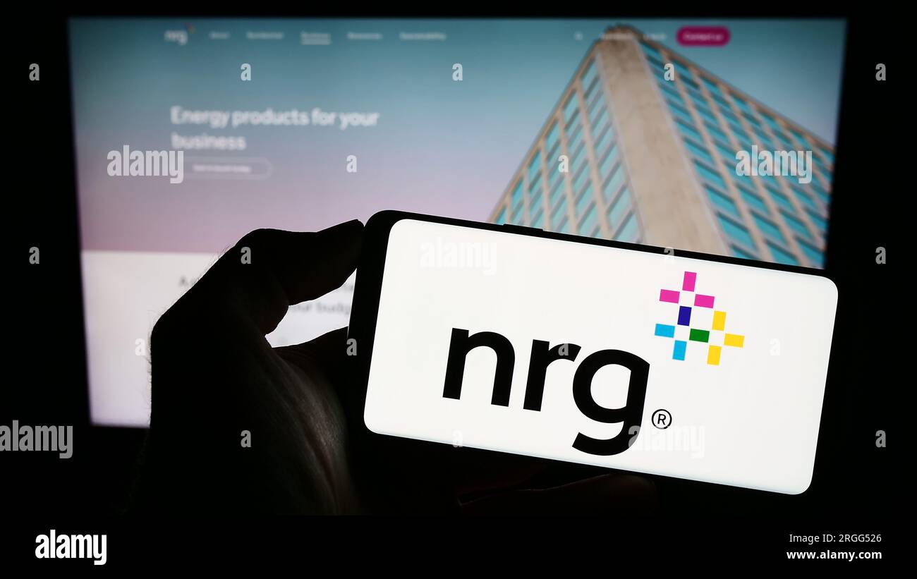 Personne tenant un smartphone avec le logo de la société de services publics américaine NRG Energy Inc. Sur l'écran devant le site Web. Concentrez-vous sur l'affichage du téléphone. Banque D'Images