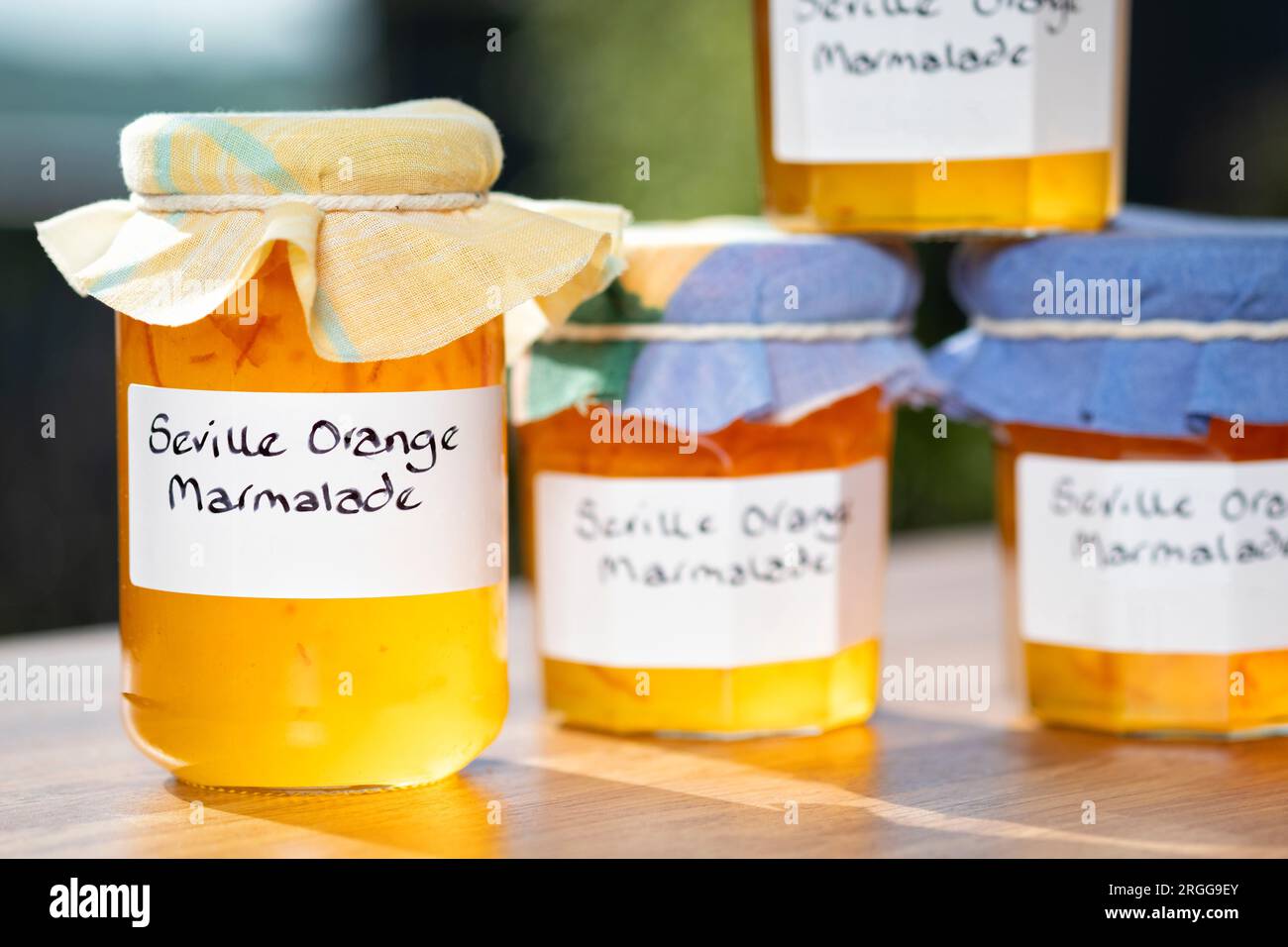 Un groupe de bocaux contenant de la marmelade d'orange de Séville faite maison. Les bocaux ont des étiquettes écrites à la main et des garnitures en tissu sur les couvercles Banque D'Images