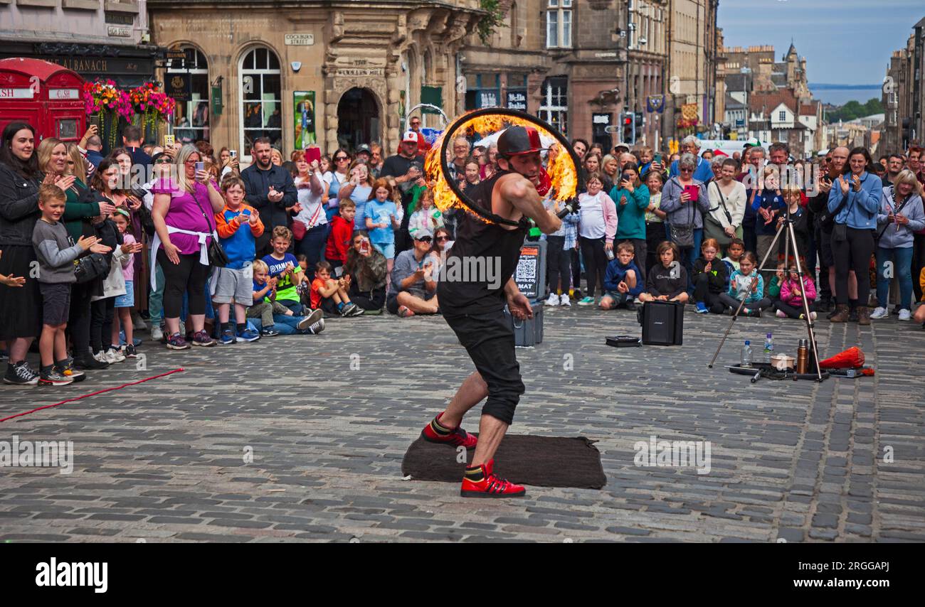 Centre-ville, Édimbourg, Écosse, Royaume-Uni. 9 août 2023. Au milieu de la première semaine de l'Edinburgh Festival Fringe with Street Performers parcourt la ville en restant assez occupé avec un grand public sur deux emplacements sur High Street, Royal Mile, et aussi Waverley Bridge. Sur la photo, Mat E Tricks avec sa performance d'arceau de feu. Crédit : Archwhite/alamy Live News. Banque D'Images
