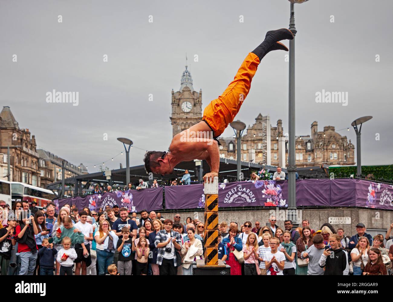Centre-ville, Édimbourg, Écosse, Royaume-Uni. 9 août 2023. Au milieu de la première semaine du Festival d'Édimbourg Fringe with Street Performers fait le tour de la ville en restant assez occupé avec un grand public sur deux emplacements sur High Street, Royal Mile, et en photo : HeroMacro effectue son numéro d'équilibre à Waverley Bridge. Crédit : Archwhite/alamy Live News. Banque D'Images