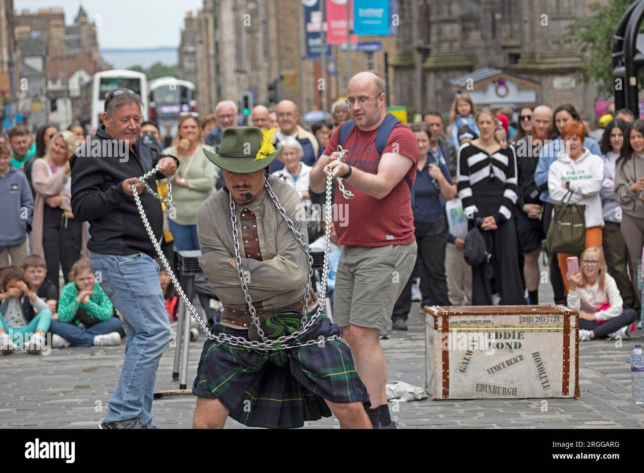 Centre-ville, Édimbourg, Écosse, Royaume-Uni. 9 août 2023. Au milieu de la première semaine du Festival d'Édimbourg Fringe with Street Performers fait le tour de la ville, avec un grand public sur deux emplacements sur High Street, Royal Mile, en photo : Eddie Bond se fait envelopper de chaînes pour s'échapper de la routine des vestes Straight. Crédit : Archwhite/alamy Live News. Banque D'Images