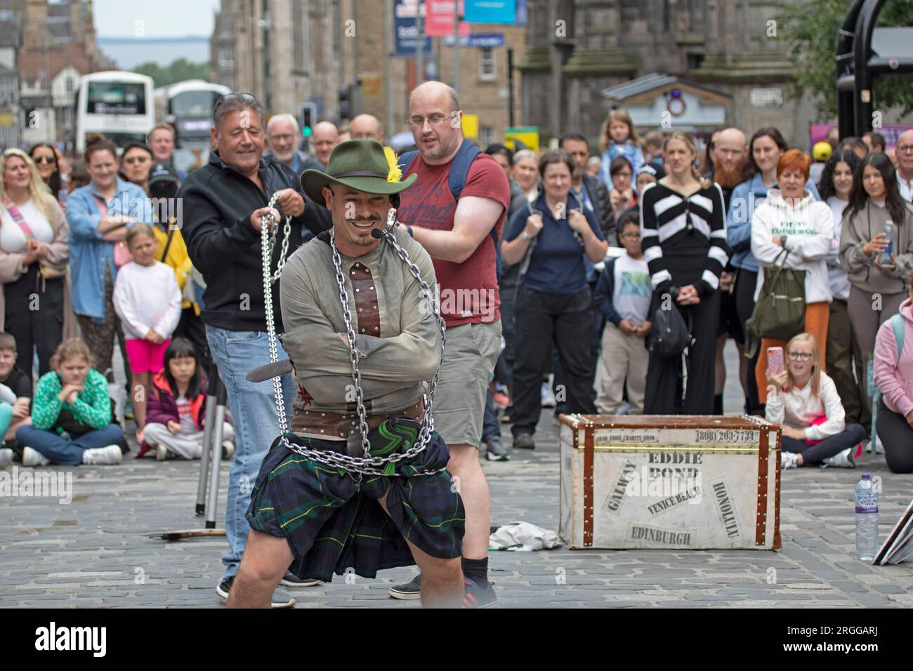Centre-ville, Édimbourg, Écosse, Royaume-Uni. 9 août 2023. Au milieu de la première semaine du Festival d'Édimbourg Fringe with Street Performers fait le tour de la ville, avec un grand public sur deux emplacements sur High Street, Royal Mile, en photo : Eddie Bond se fait envelopper de chaînes pour s'échapper de la routine des vestes Straight. Crédit : Archwhite/alamy Live News. Banque D'Images