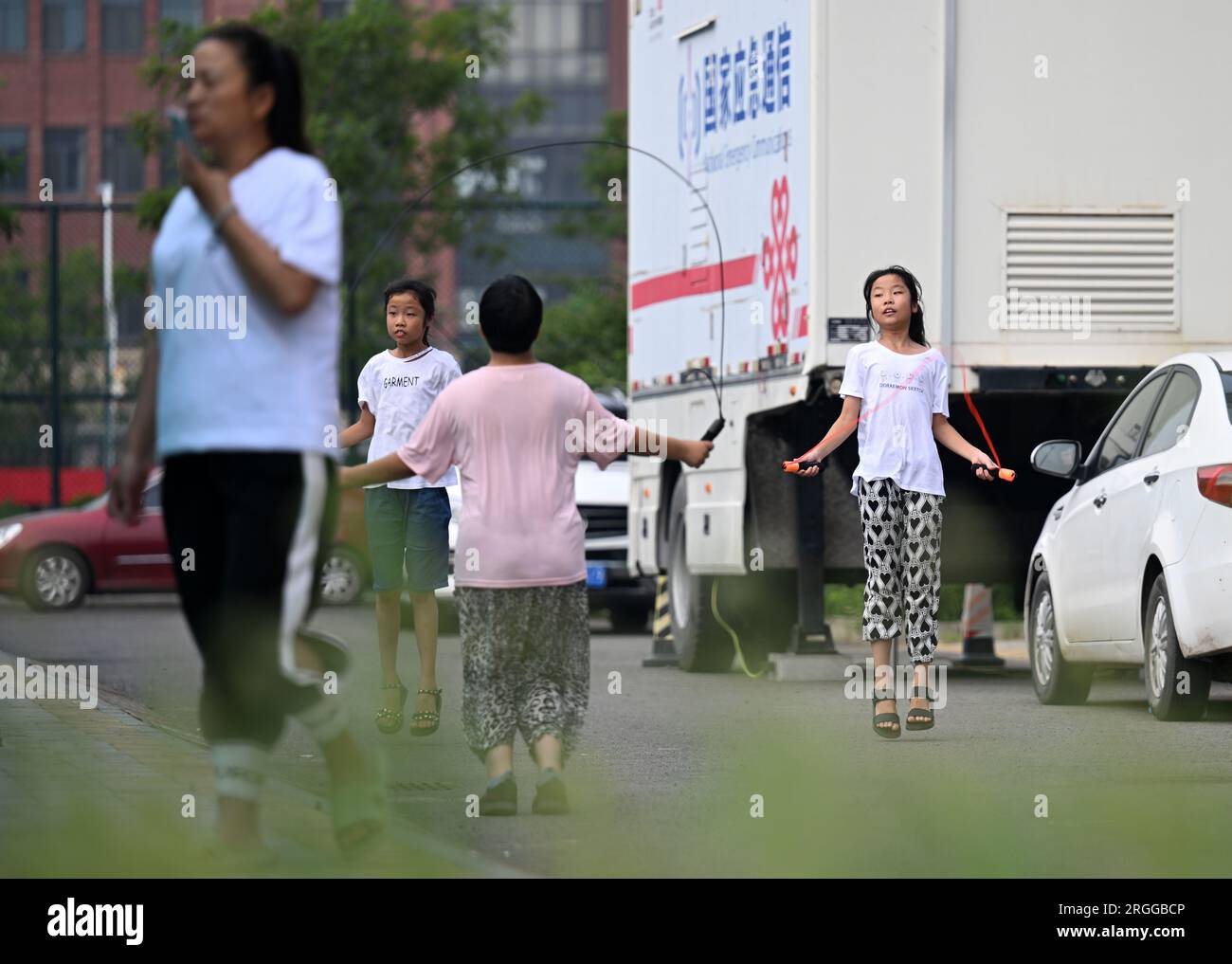 Tianjin, Chine. 9 août 2023. Les enfants s’amusent sur un site de relocalisation à Tianjin, dans le nord de la Chine, le 9 août 2023. Le district de Jinghai à Tianjin, dans le nord de la Chine, a fait des efforts pour protéger la vie de plus de 2 000 habitants touchés par les inondations après la mise en service d'une zone de rétention et de rétention des eaux de crue. Crédit : Li Ran/Xinhua/Alamy Live News Banque D'Images