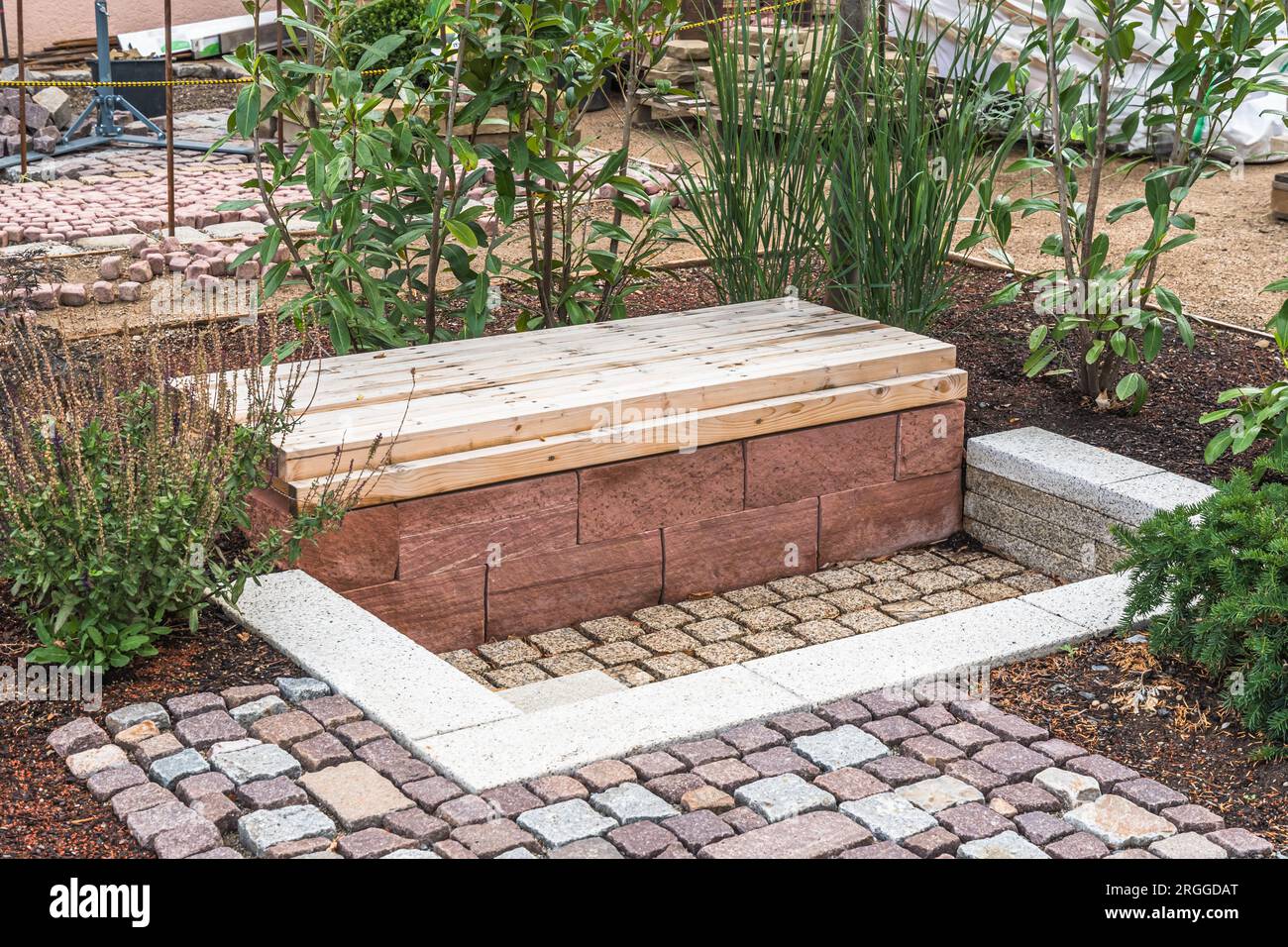 Coin salon ombragé confortable en béton et bois dans un jardin Banque D'Images