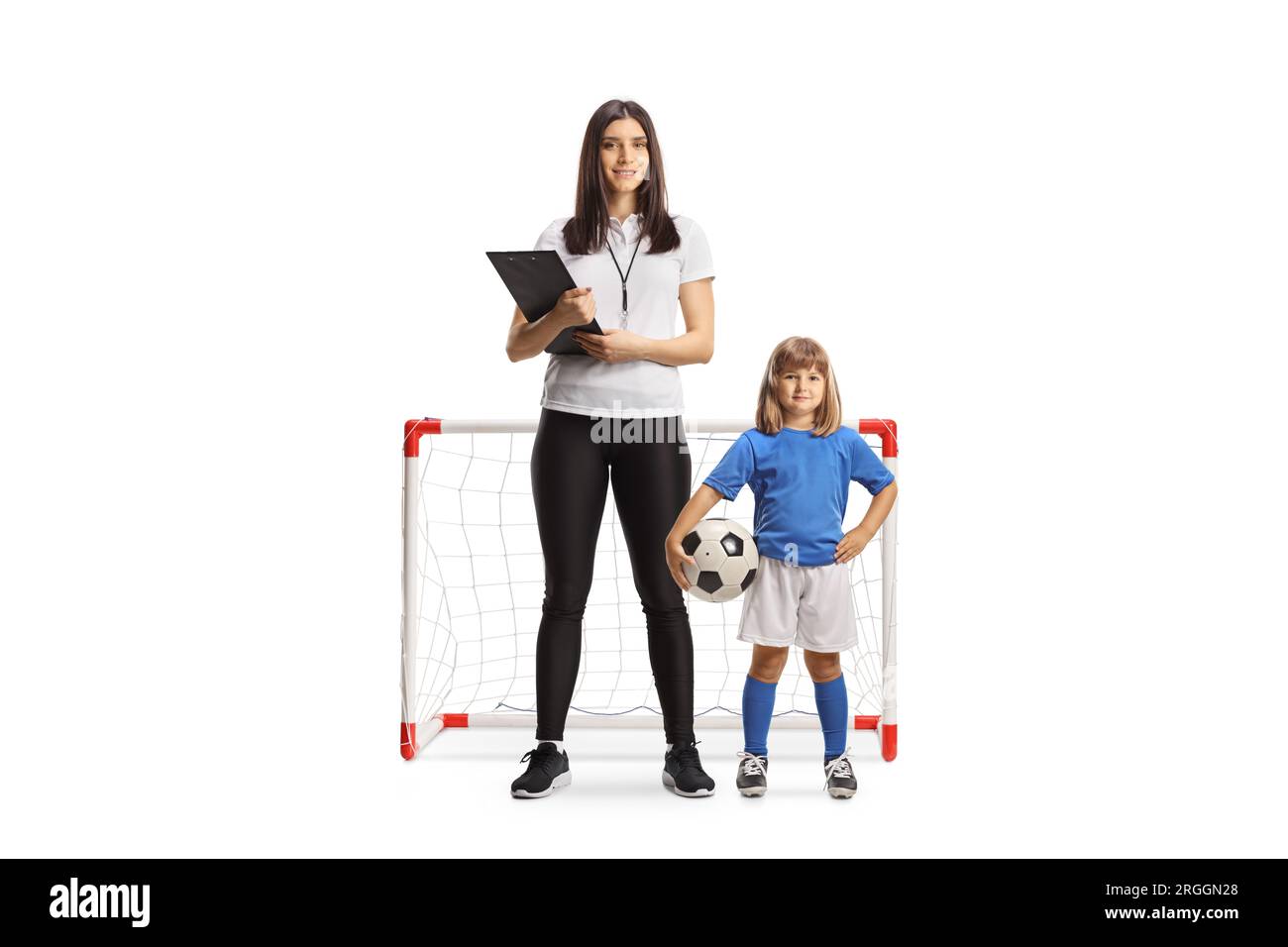 Enseignante PE féminine debout devant un mini but avec une petite fille isolée sur fond blanc Banque D'Images