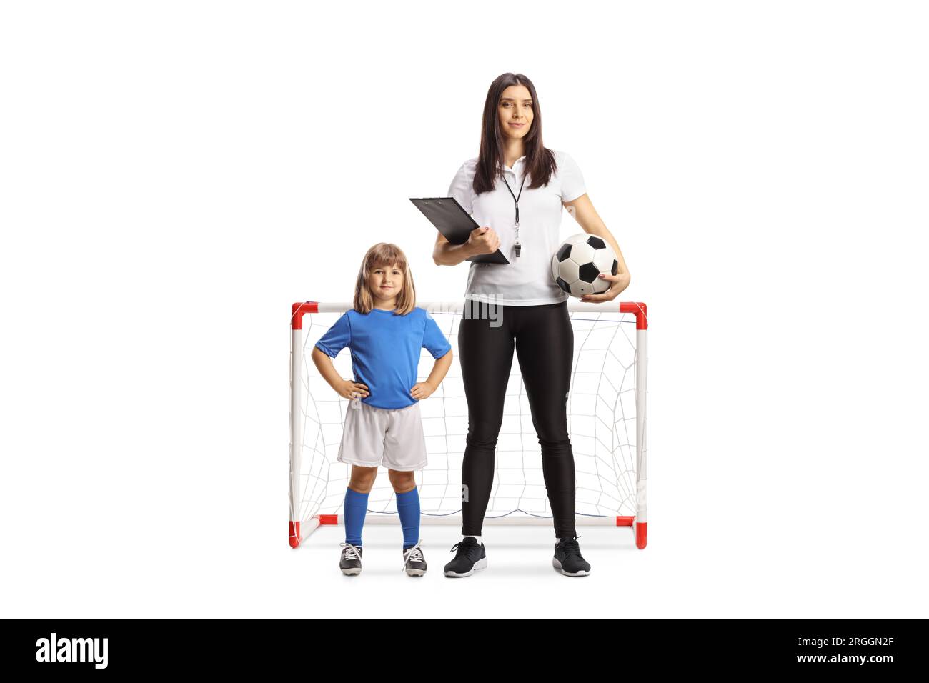 Entraîneur de football féminin debout devant un mini but avec une petite fille isolée sur fond blanc Banque D'Images