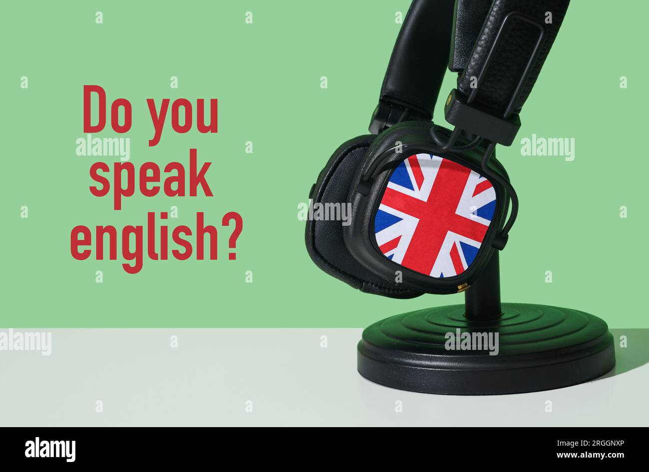 la question parlez-vous anglais et une paire d'écouteurs modelés avec le  drapeau du royaume-uni, sur une surface blanche, devant un dos vert Photo  Stock - Alamy