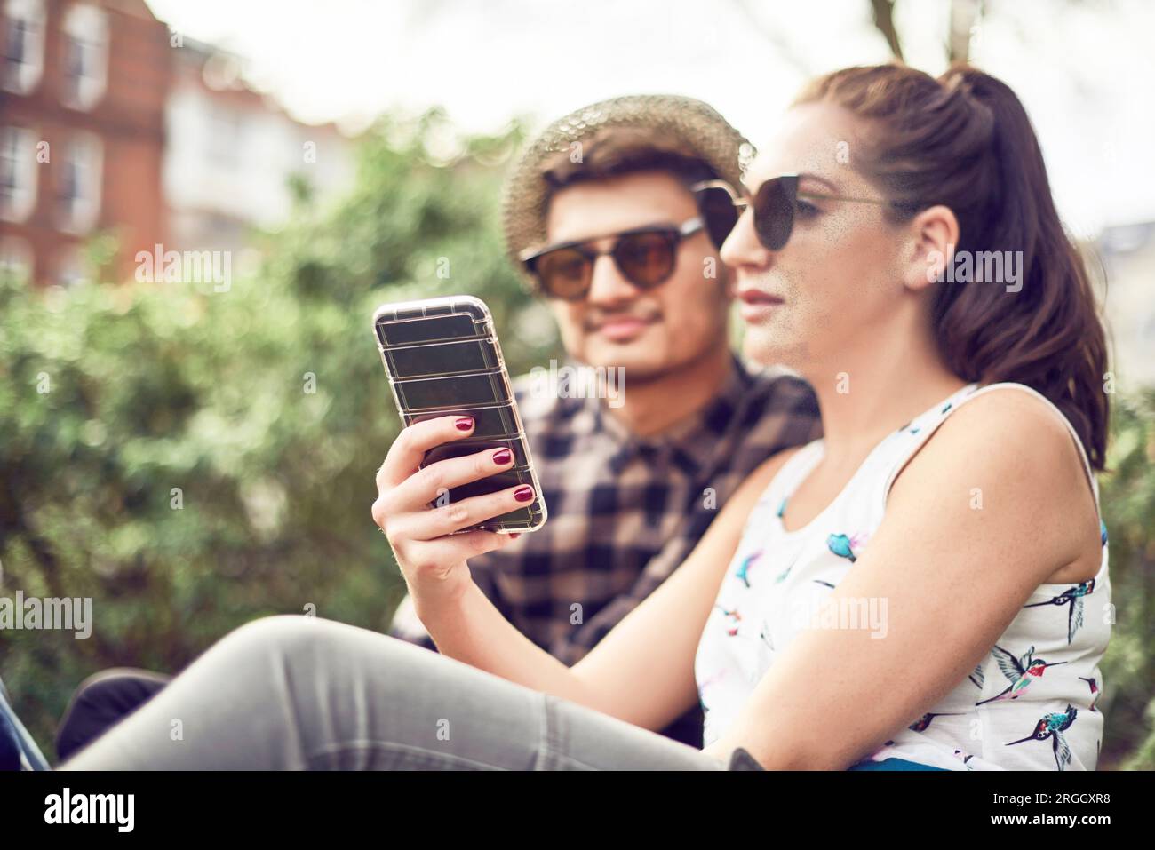 Teenage couple sitting in park Banque D'Images