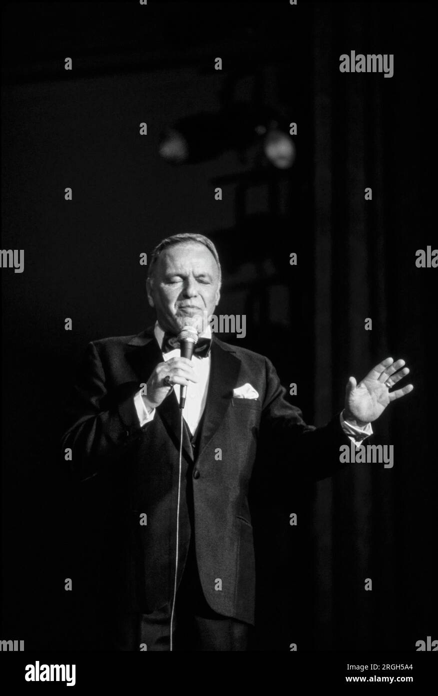 Frank Sinatra en performance, 1982. Photographie de Bernard Gotfryd . Francis Albert Sinatra était un chanteur et acteur américain. Surnommé le «président du conseil d'administration» et plus tard appelé «Ol' Blue Eyes», il est considéré comme l'un des artistes les plus populaires du milieu du 20e siècle. Sinatra est parmi les artistes musicaux les plus vendus au monde avec environ 150 millions de ventes de disques. Né d'immigrants italiens à Hoboken, New Jersey, Sinatra a commencé sa carrière musicale à l'ère du swing. Banque D'Images
