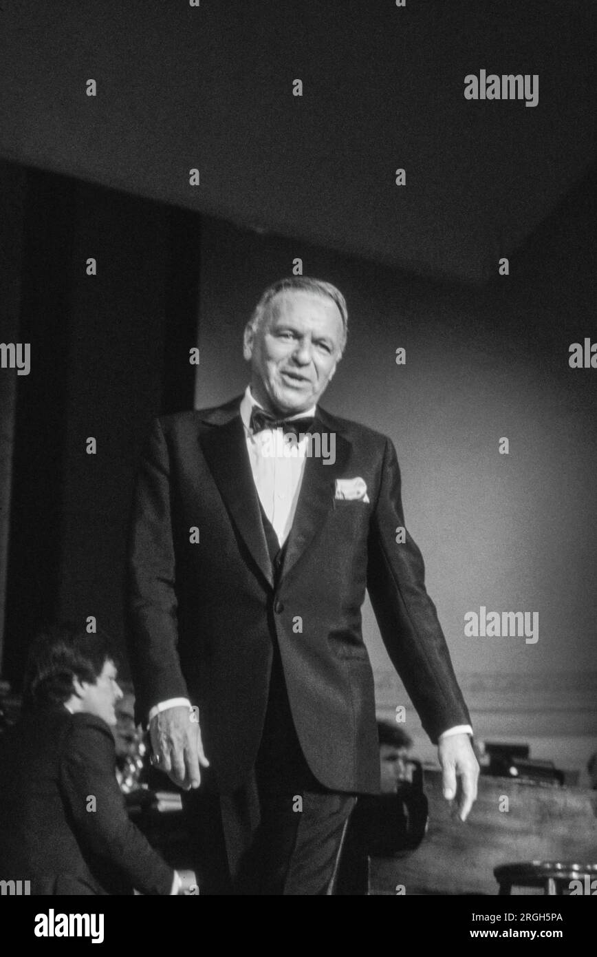 Frank Sinatra en performance, 1982. Photographie de Bernard Gotfryd . Francis Albert Sinatra était un chanteur et acteur américain. Surnommé le «président du conseil d'administration» et plus tard appelé «Ol' Blue Eyes», il est considéré comme l'un des artistes les plus populaires du milieu du 20e siècle. Sinatra est parmi les artistes musicaux les plus vendus au monde avec environ 150 millions de ventes de disques. Né d'immigrants italiens à Hoboken, New Jersey, Sinatra a commencé sa carrière musicale à l'ère du swing. Banque D'Images