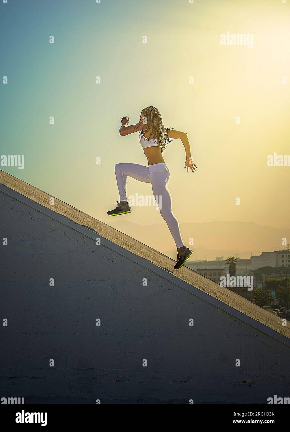 Jeune femme tournant sur une rampe sur le toit Banque D'Images