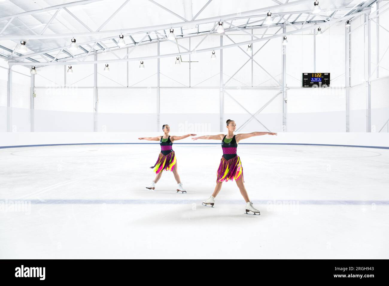 Deux jeunes femmes qui pratiquent le patinage synchronisé à la patinoire Banque D'Images