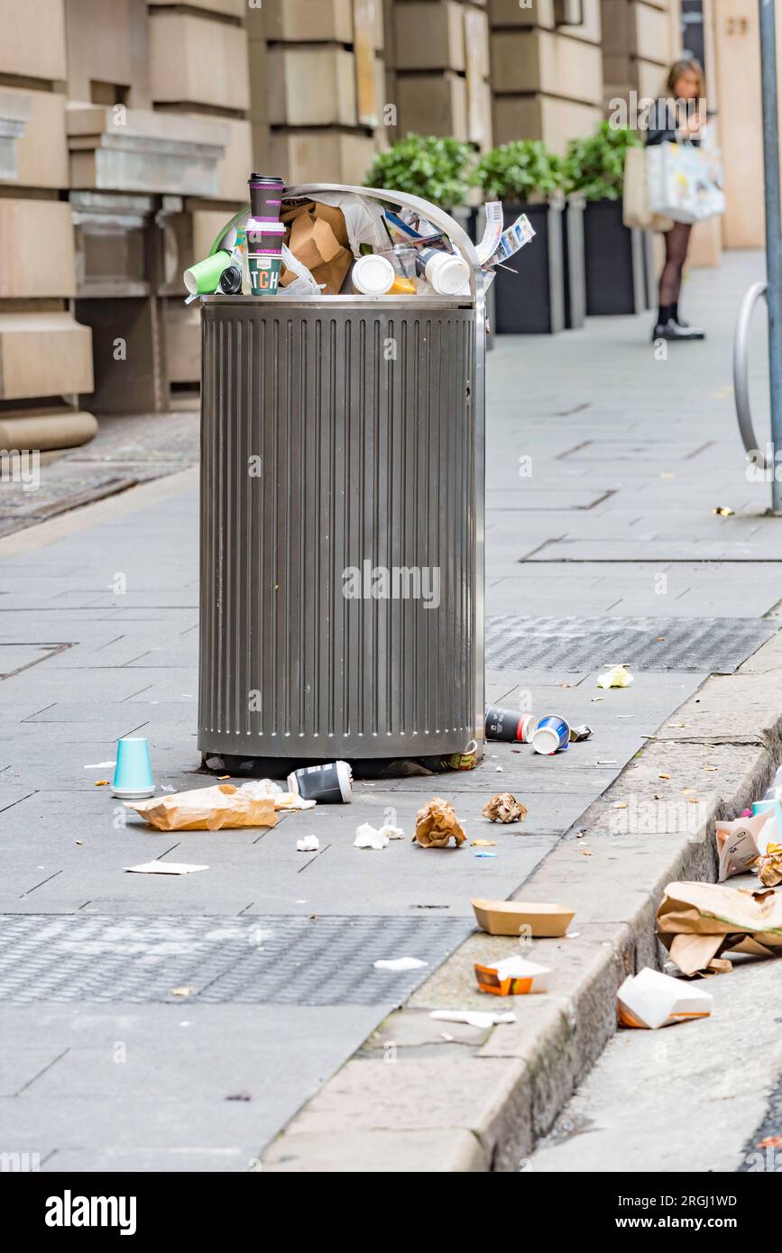Tasses à café et conteneurs de nourriture dans la rue et les déchets débordant d'une poubelle trop pleine dans le centre de Sydney, Nouvelle-Galles du Sud, Australie Banque D'Images