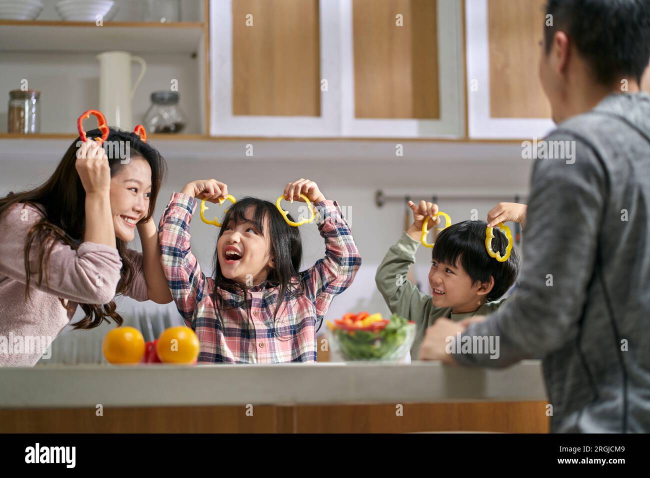 famille asiatique heureuse avec deux enfants s'amusant ensemble dans la cuisine à la maison Banque D'Images