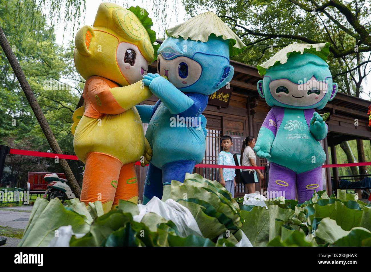 Les mascottes des Jeux asiatiques de Hangzhou vendent des graines de lotus et des feuilles de lotus dans un bazar caritatif près du lac de l'Ouest dans la ville de Hangzhou, province du Zhejiang dans l'est de la Chine, le 8 août 2023. (Photo ChinaImages/Sipa USA) crédit : SIPA US/Alamy Live News Banque D'Images
