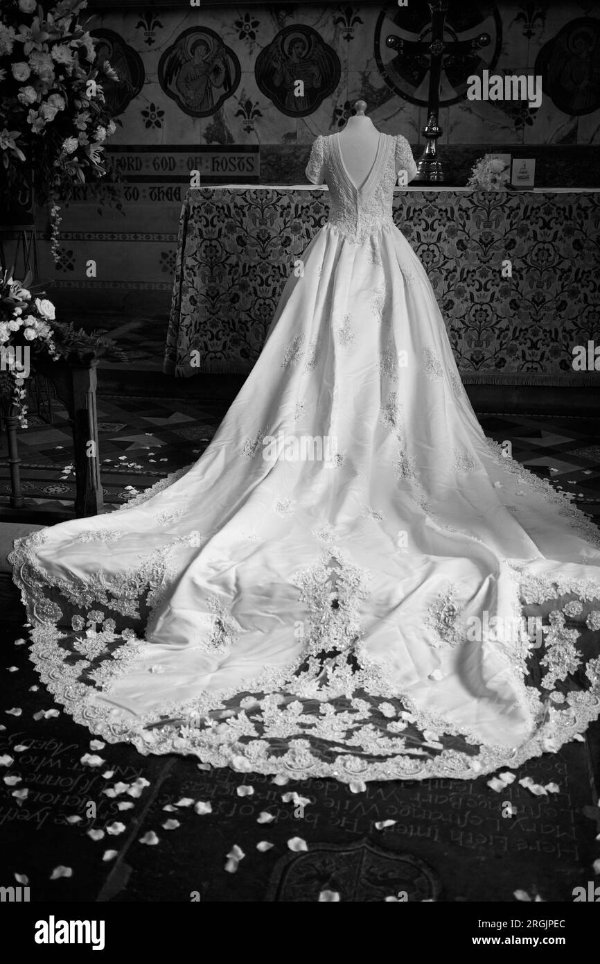 Robe de mariée blanche exposée devant l'autel d'une église. Banque D'Images