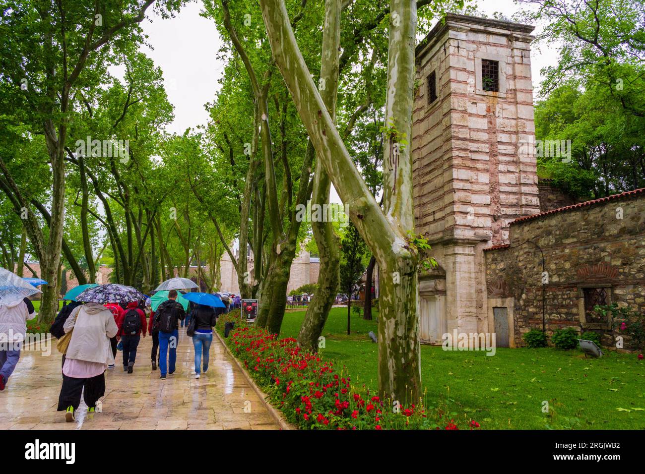 Touristes marchant sous la pluie sur une passerelle menant au palais de Topkapi Sarayi-SITE du patrimoine mondial de l'UNESCO .Topkapi est un grand musée et une bibliothèque. Banque D'Images