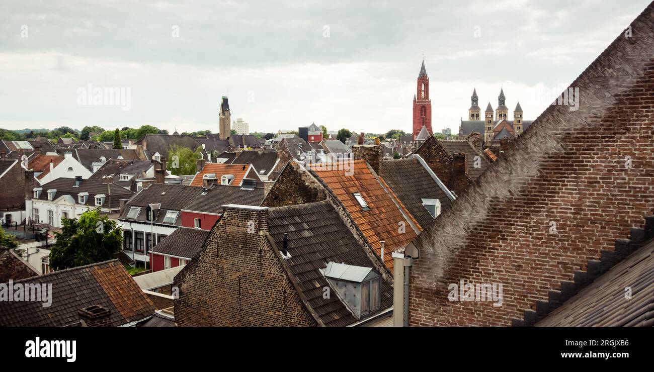 Toits du centre-ville de Maastricht le dimanche après-midi. Paysage urbain avec toits de tuiles et cheminées de vieux bâtiments Banque D'Images