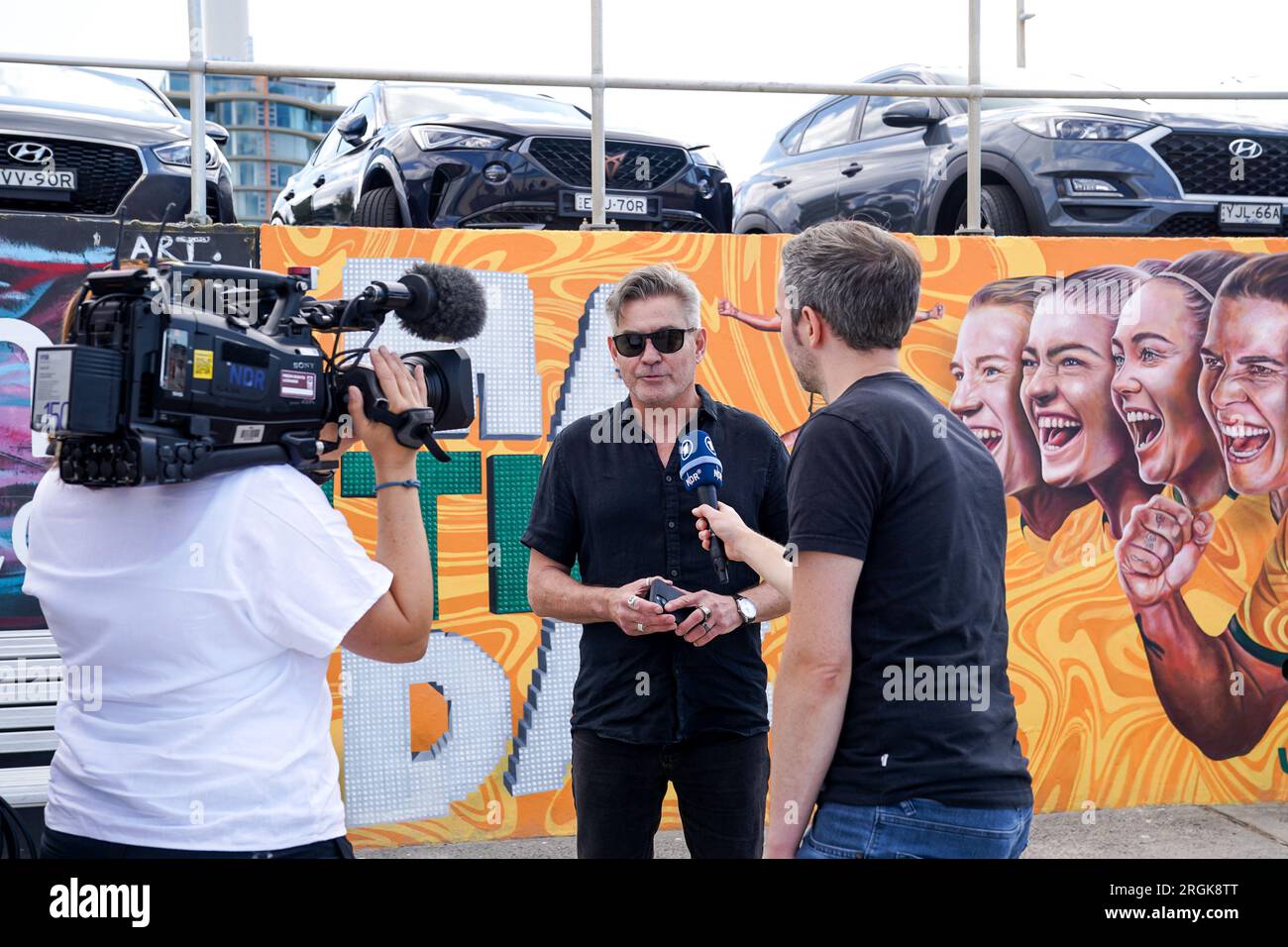 Sydney, Australie. 10 août 2023. Sydney, Australie, 10 août 2023 : ARD NRD télévision allemande interviewant et filmant une fan devant le travail d'art graffiti avec le slogan Til It's Done en l'honneur des Matildas, l'équipe nationale féminine d'Australie, créé par Danielle Weber (Daniellesartwork) lors de la coupe du monde féminine FIFA 2023 à Bondi Beach à Sydney, Australie. (Daniela Porcelli/SPP) crédit : SPP Sport Press photo. /Alamy Live News Banque D'Images